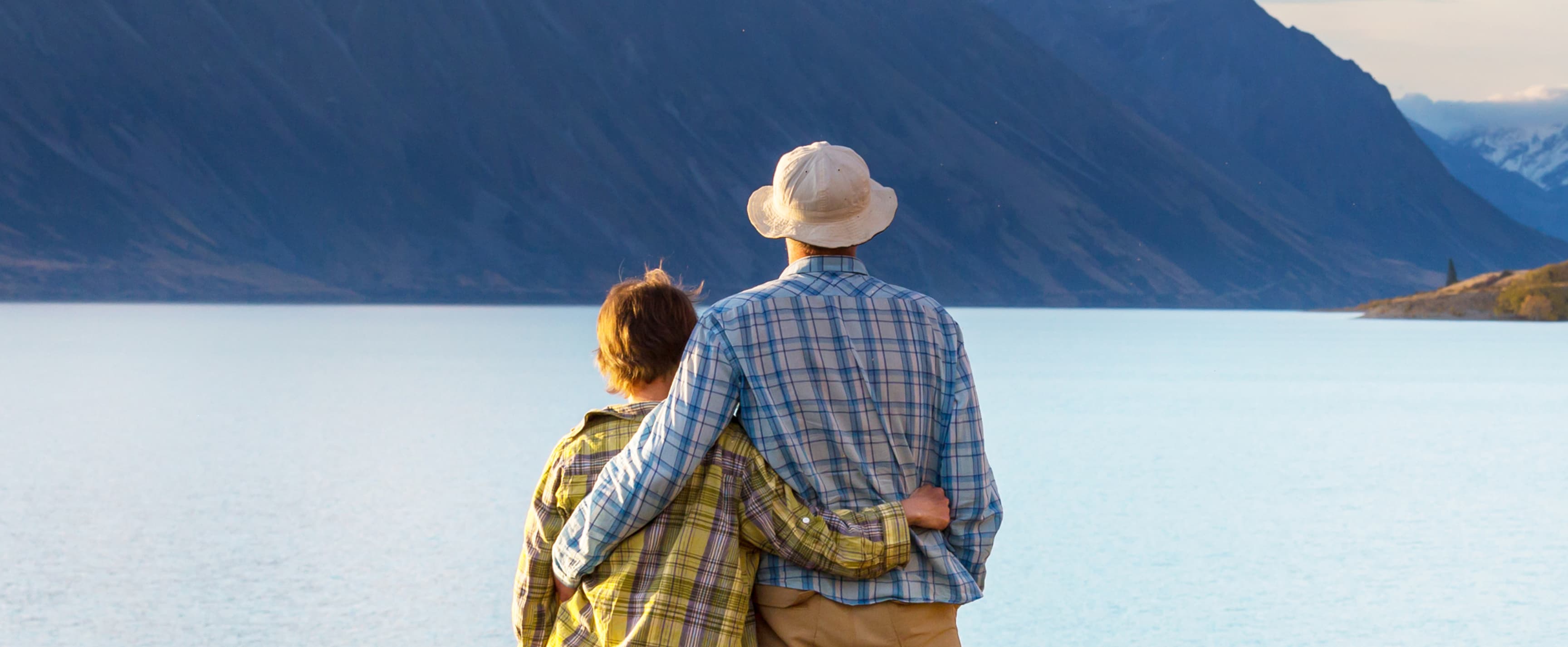 Woman and man embracing looking out over a lake
